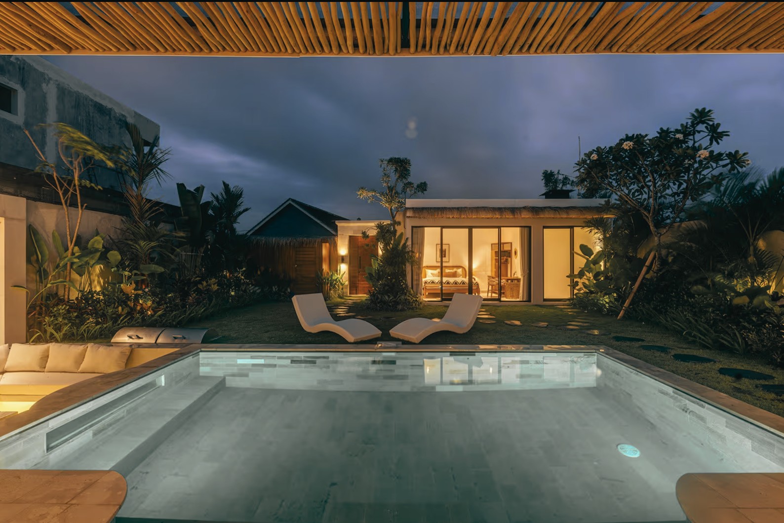 Bayani Sanctuary Villa in Canggu, Bali — infinity pool at dusk surrounded by tropical greenery